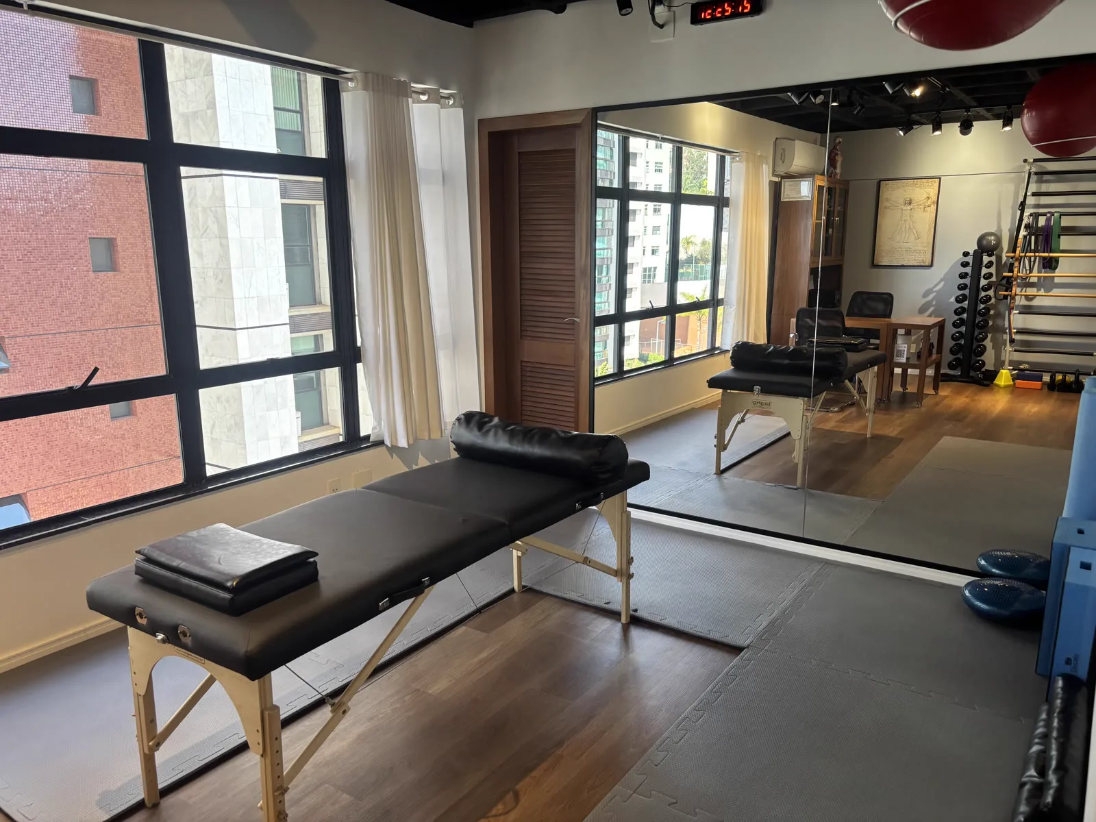 Sala de atendimento com maca portátil e vista para a cidade